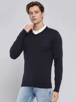 Man wearing 98degreenorth Men’s Dark Navy Merino Wool V-Neck Sweater over a white shirt and light blue jeans.