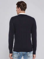 A man wears a 98degreenorth Dark Navy Merino Wool V-Neck Sweater with light blue jeans, facing away from the camera.