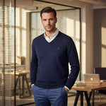A man wears the 98degreenorth Men’s Dark Navy Merino Wool V-Neck Sweater, perfect for classic office style.