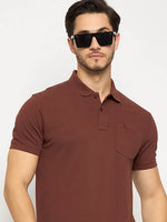 Man in 98degreenorth Dark Rust Polo T-Shirt with chest pocket and large black sunglasses, against a plain background.