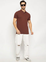 Man in 98degreenorth dark rust stretch cotton pique polo with chest pocket, white ripped jeans, and gray sneakers.