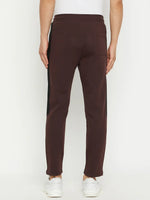 A man wears 98degreenorth Men's Dark Wine Fleece Trackpants with side panel, back facing the camera.