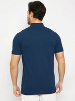 A man wears the 98degreenorth Men's Denim Blue Polo T-Shirt, pure cotton pique with chest pocket, shown from the back.