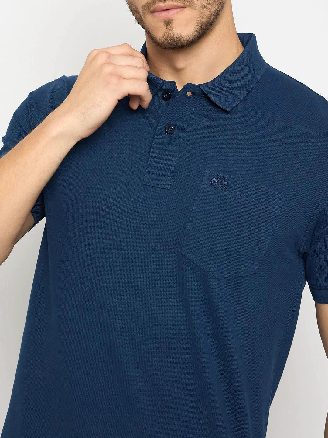 Man wears 98degreenorth Men's Denim Blue Pure Cotton Pique Polo with chest pocket, touching the collar.