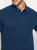 Man in 98degreenorth Men's Denim Blue Solid Cotton Pique Polo with collar, buttons, and chest logo.