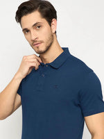 Man in a 98degreenorth Men's Denim Blue Solid Polo T-Shirt poses against a plain background.