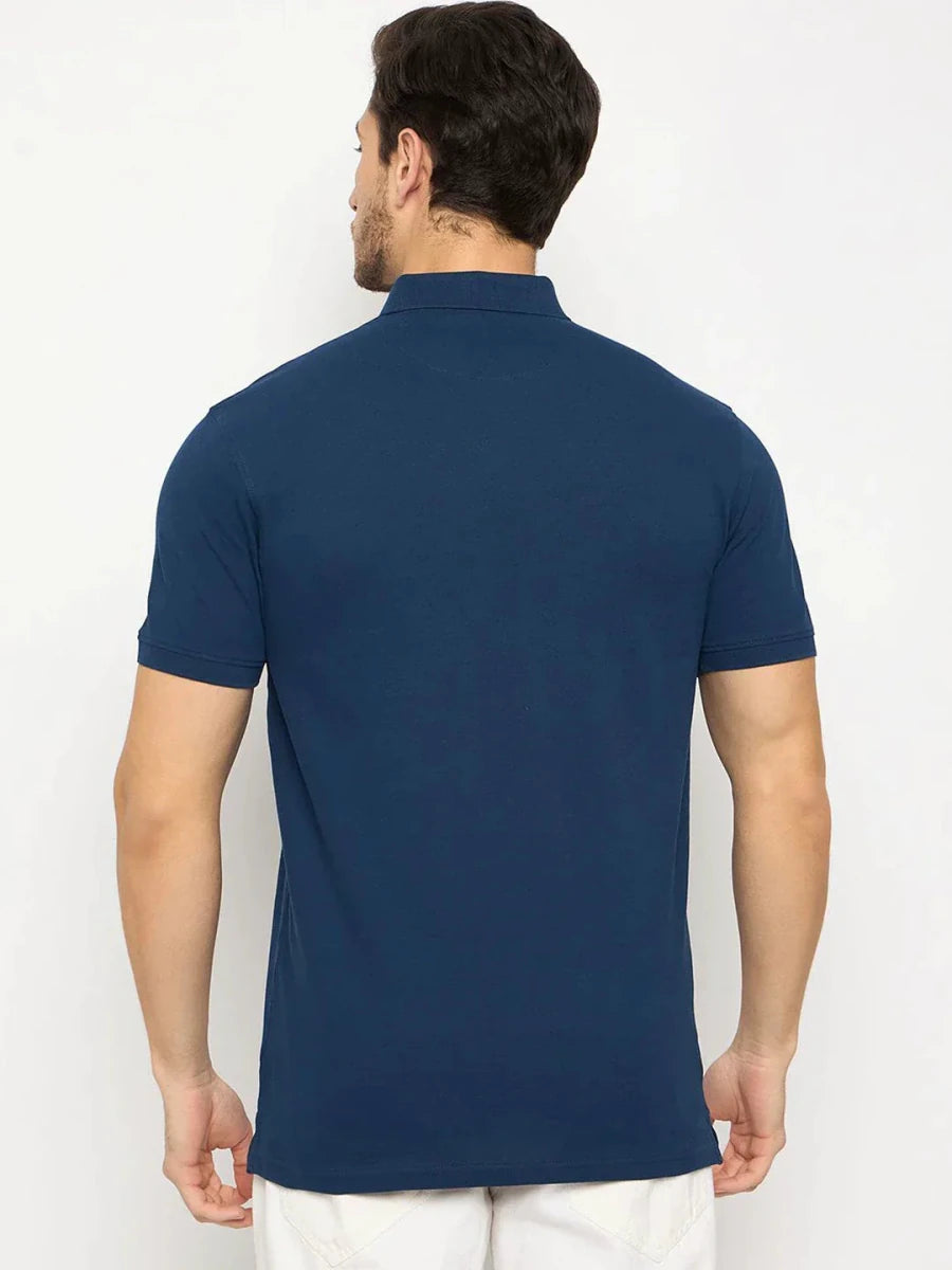 Man wearing 98degreenorth Men's Denim Blue Solid Polo T-Shirt—Cotton Pique, facing away in white pants.