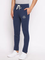 Man wears 98degreenorth Men’s Denim Fleece Trackpants, trendy knit joggers for travel & fitness, with white sneakers.