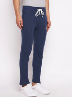 A person wears 98degreenorth Men’s Denim Fleece Trackpants, trendy knit joggers, with sneakers against a plain background.