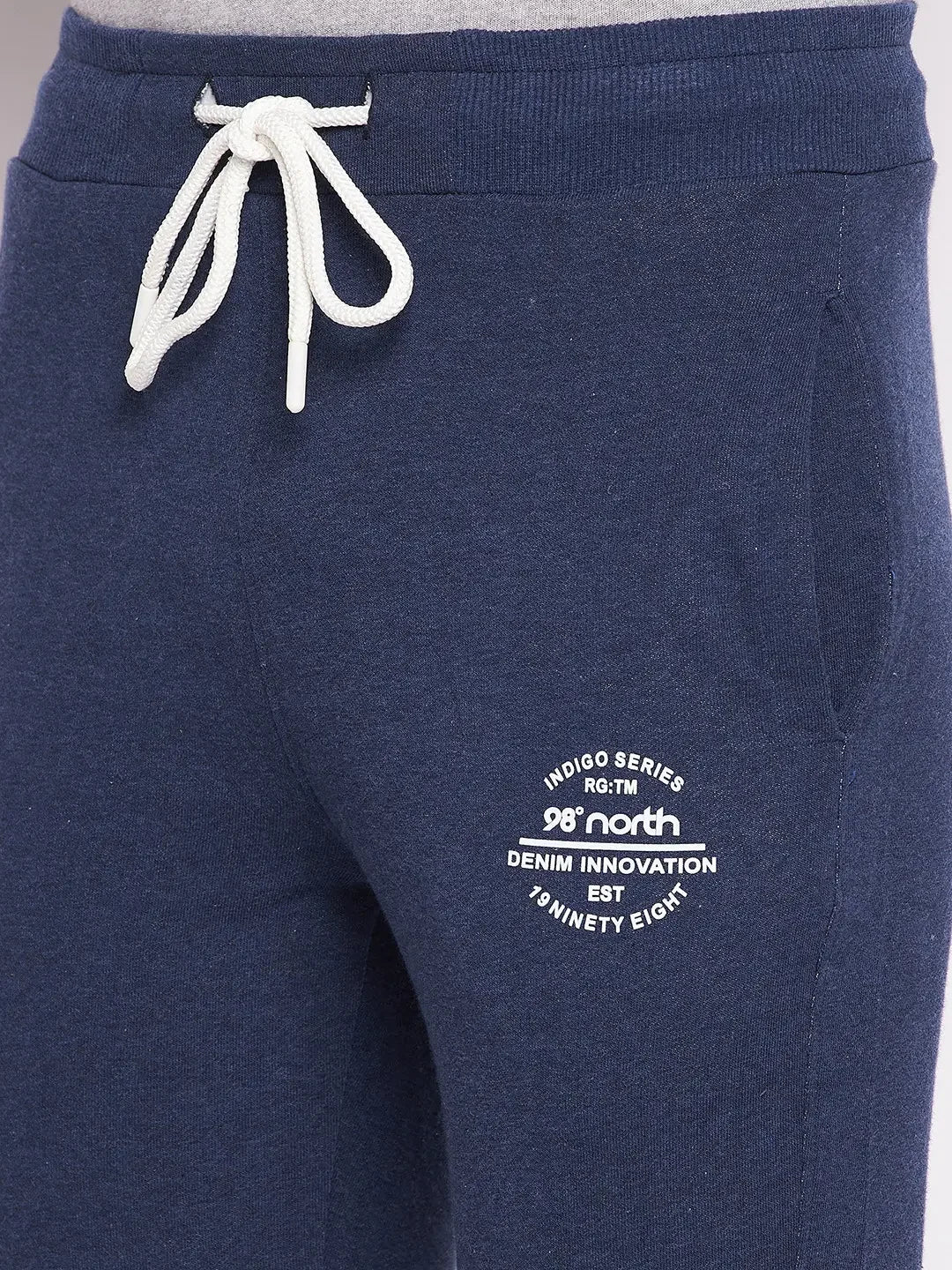 Close-up of 98degreenorth Men’s Denim Fleece Trackpants with white drawstring and logo on left thigh.