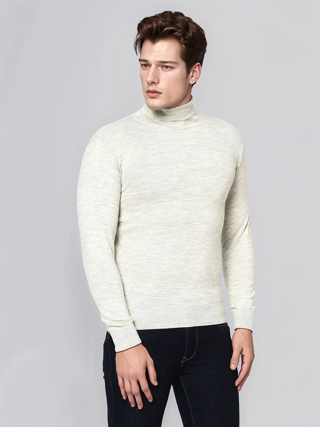 A man wears the 98degreenorth Men’s Ecru Merino Wool Turtle Neck Sweater against a plain light gray background.