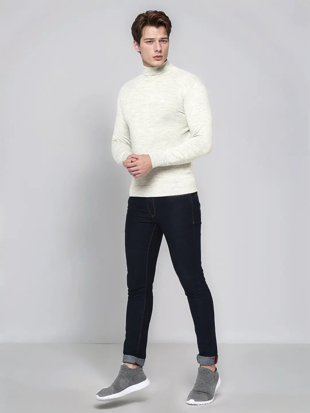 A man in a 98degreenorth Men’s Ecru Merino Wool Turtle Neck Sweater & jeans, smart casual India.