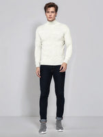 A man wears a 98degreenorth Men's Ecru Merino Wool Turtle Neck Sweater, dark jeans, and gray slip-on shoes.