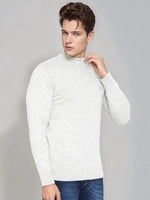 A man in a 98degreenorth Men’s Ecru Merino Wool Turtle Neck Sweater and blue jeans poses against a light gray background.