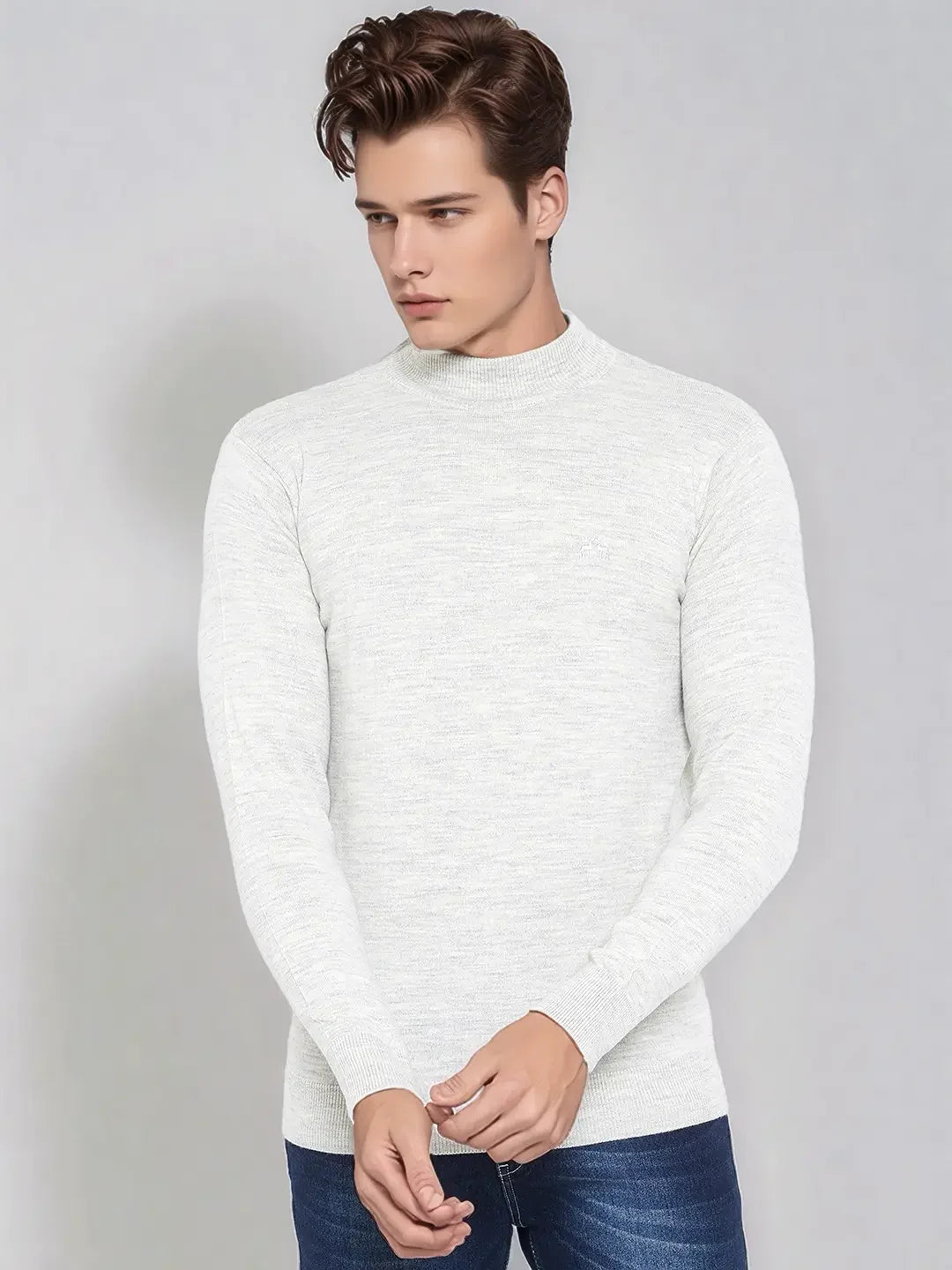 Man wears 98degreenorth Men’s Ecru Merino Wool Turtle Neck Sweater with jeans, standing against a plain light background.