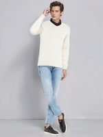 A man wears the 98degreenorth Men’s Ecru Merino Wool V-Neck Sweater with blue jeans and black sneakers.