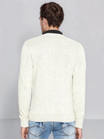 A man wears the 98degreenorth Men’s Ecru Merino Wool V-Neck Sweater and blue jeans, shown from the back.