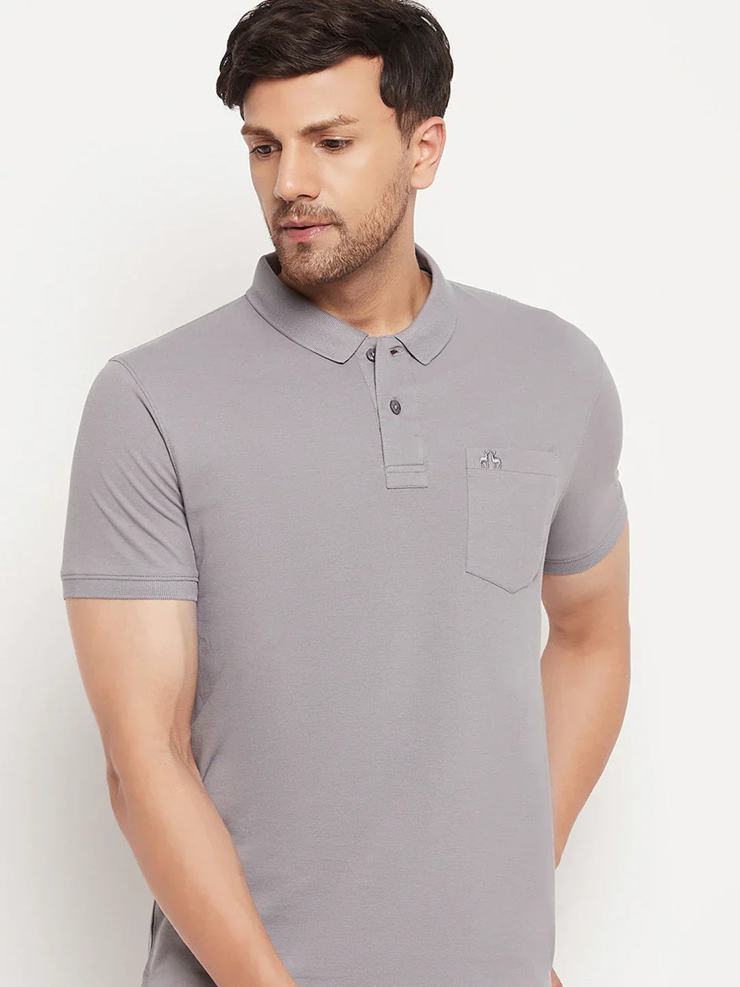 Man wears 98degreenorth Men's Grey Polo T-Shirt in stretch cotton pique with chest pocket, against white background.