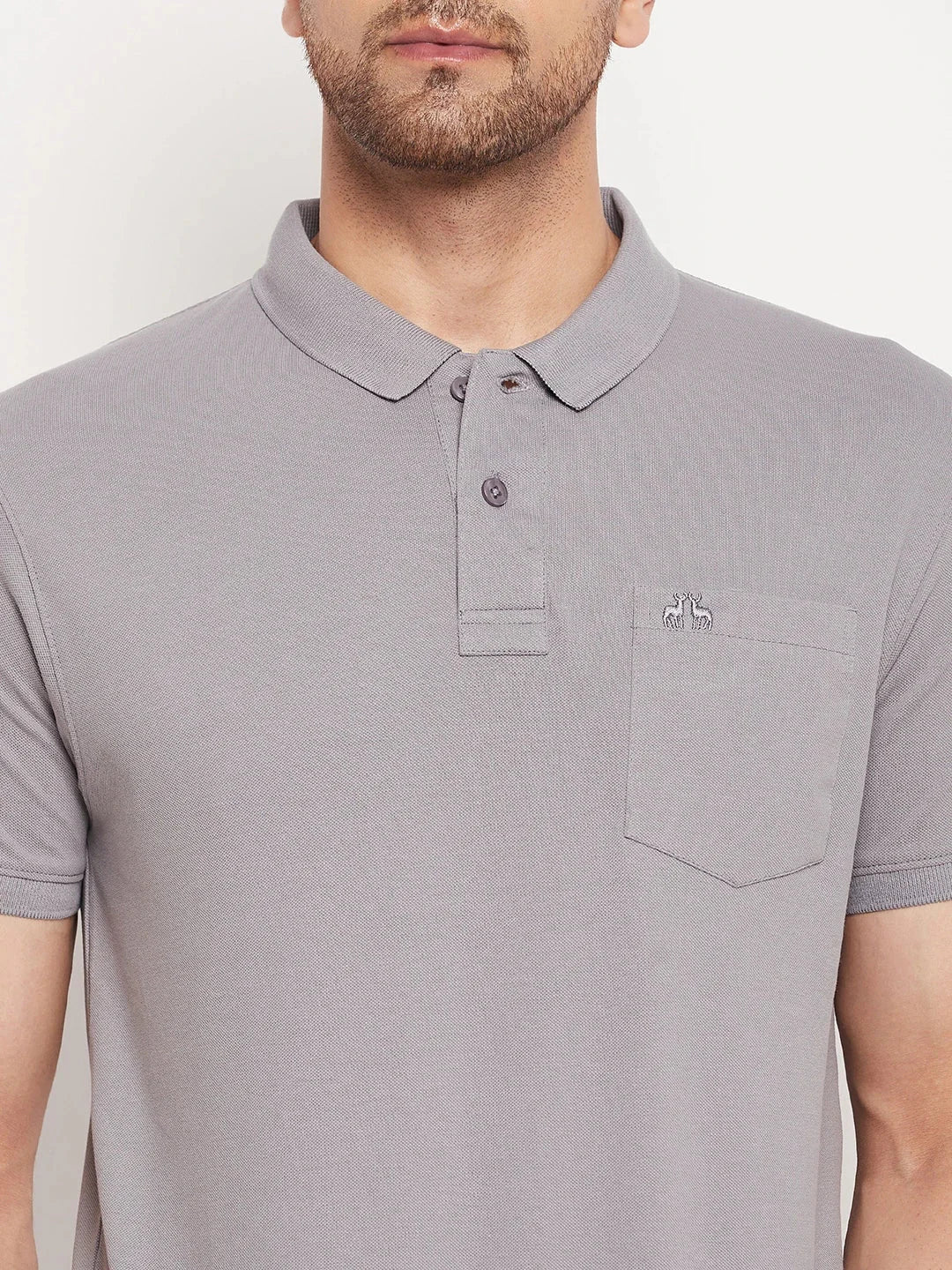 A man wears the 98degreenorth Men's Grey Polo T-Shirt in stretch cotton pique with chest pocket and small logo.