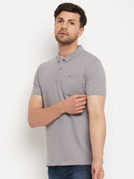 Man wears 98degreenorth Grey Polo T-Shirt—Stretch Cotton Pique with chest pocket, standing against a white background.