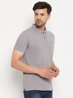 Man wears 98degreenorth Men's Grey Polo T-Shirt in stretch cotton pique with chest pocket, paired with blue jeans.