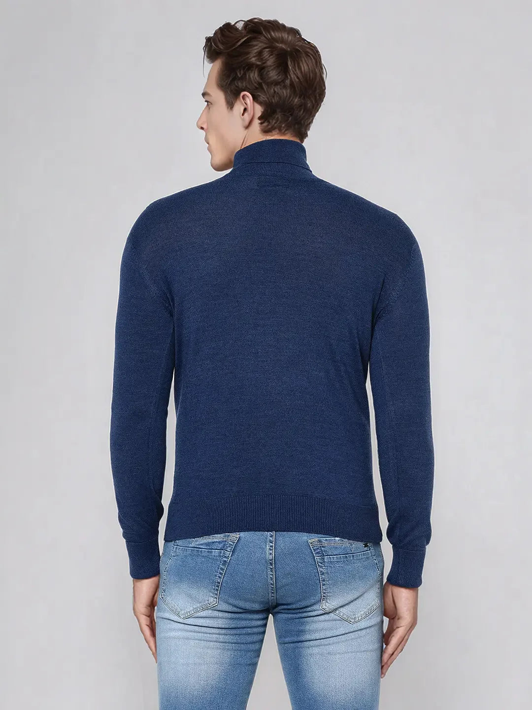 Man in 98degreenorth Men’s Light Denim Merino Wool Turtle Neck Sweater, back to camera.