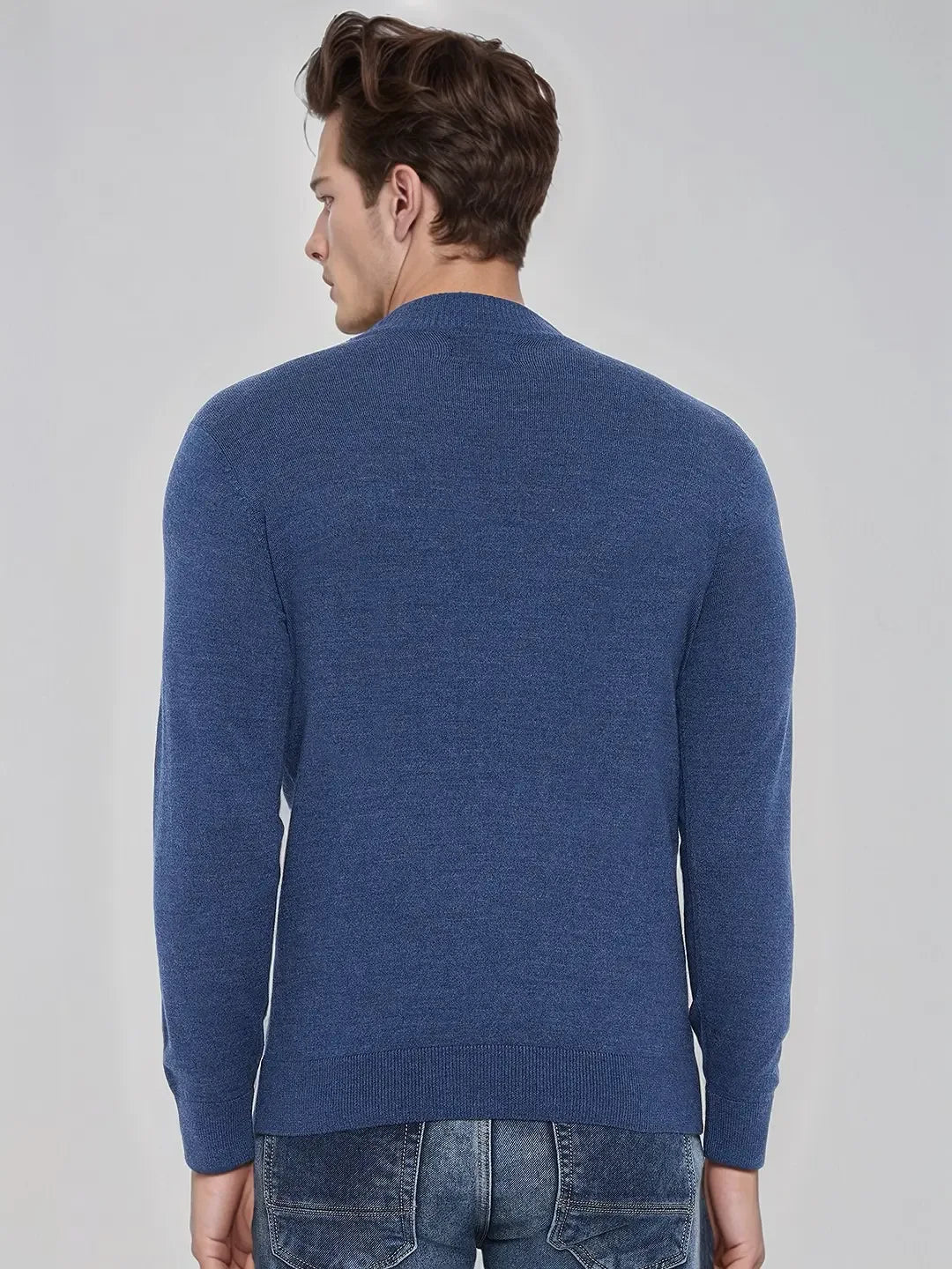 Man with short brown hair wears a 98degreenorth Men’s Light Denim Merino Wool Turtle Neck Sweater and jeans, facing away.
