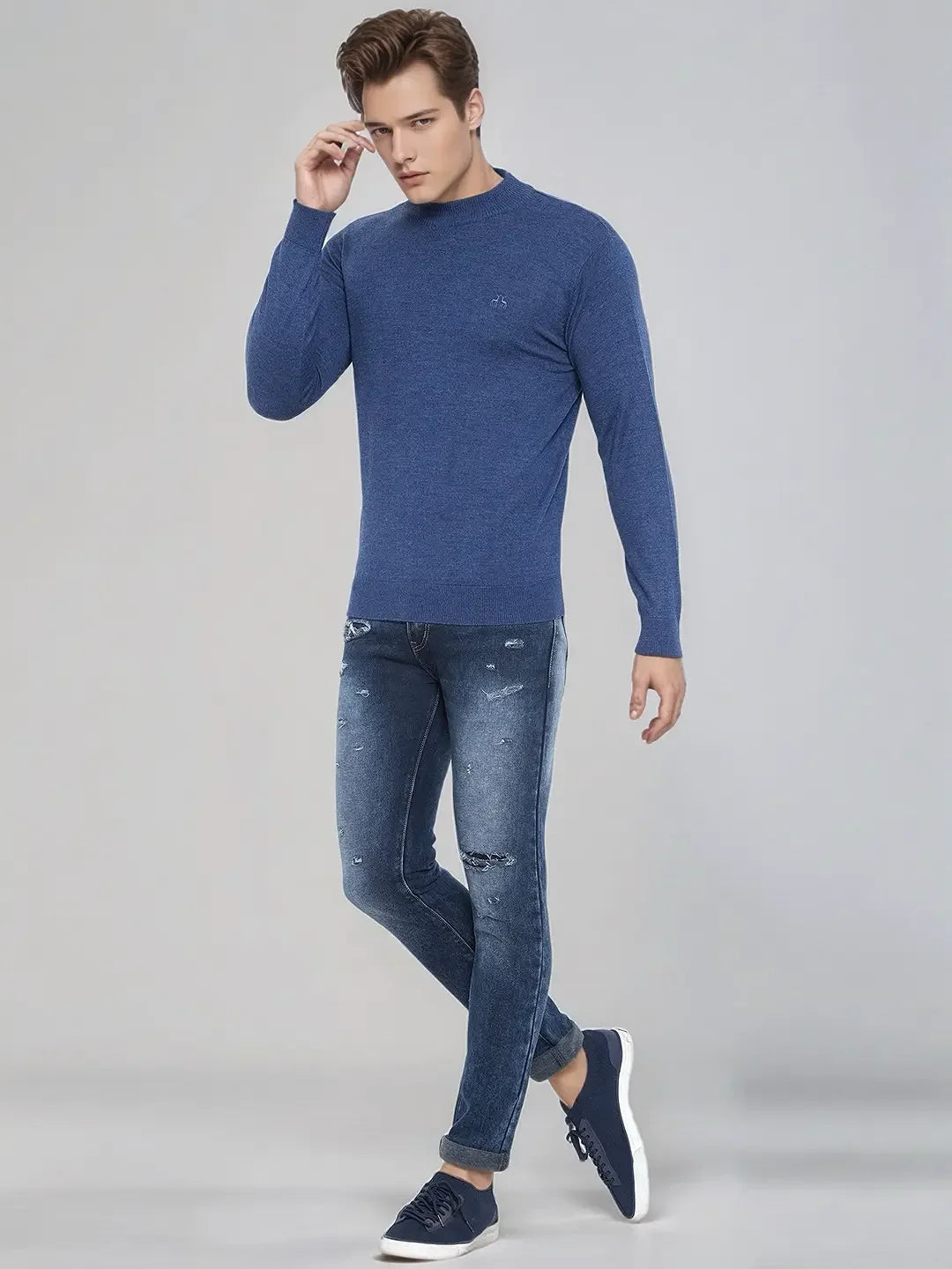 A man in a 98degreenorth Men’s Light Denim Merino Wool Turtle Neck Sweater, perfect for winter in India.