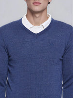 A man wears the 98degreenorth Men’s Light Denim Merino Wool V-Neck Sweater over a white shirt for a smart casual look.