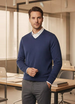A man wears the 98degreenorth Men’s Light Denim Merino Wool V-Neck Sweater in a modern office setting.