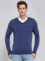 Young man in 98degreenorth Men’s Light Denim Merino Wool V-Neck Sweater, over a white shirt and light blue jeans.