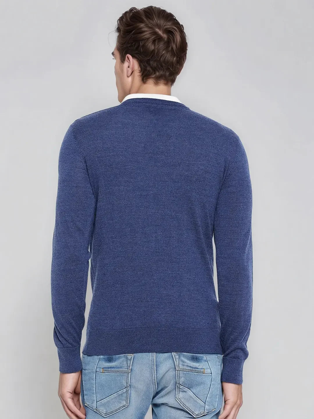 Man in a 98degreenorth Light Denim Merino Wool V-Neck Sweater, back to camera, on a plain background.