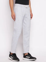Man in 98degreenorth Men’s Light Grey Fleece Trackpants with drawstring, black tee, and Adidas sneakers, on white background.
