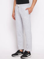 Man wears 98degreenorth Men’s Light Grey Fleece Trackpants with adjustable drawstring and black Adidas sneakers, hand in pocket.