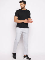 Man in 98degreenorth Men’s Light Grey Fleece Trackpants and black tee, standing against a white background.