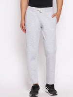 A man in 98degreenorth Men’s Light Grey Fleece Trackpants, black shirt, and sneakers stands before a white background.