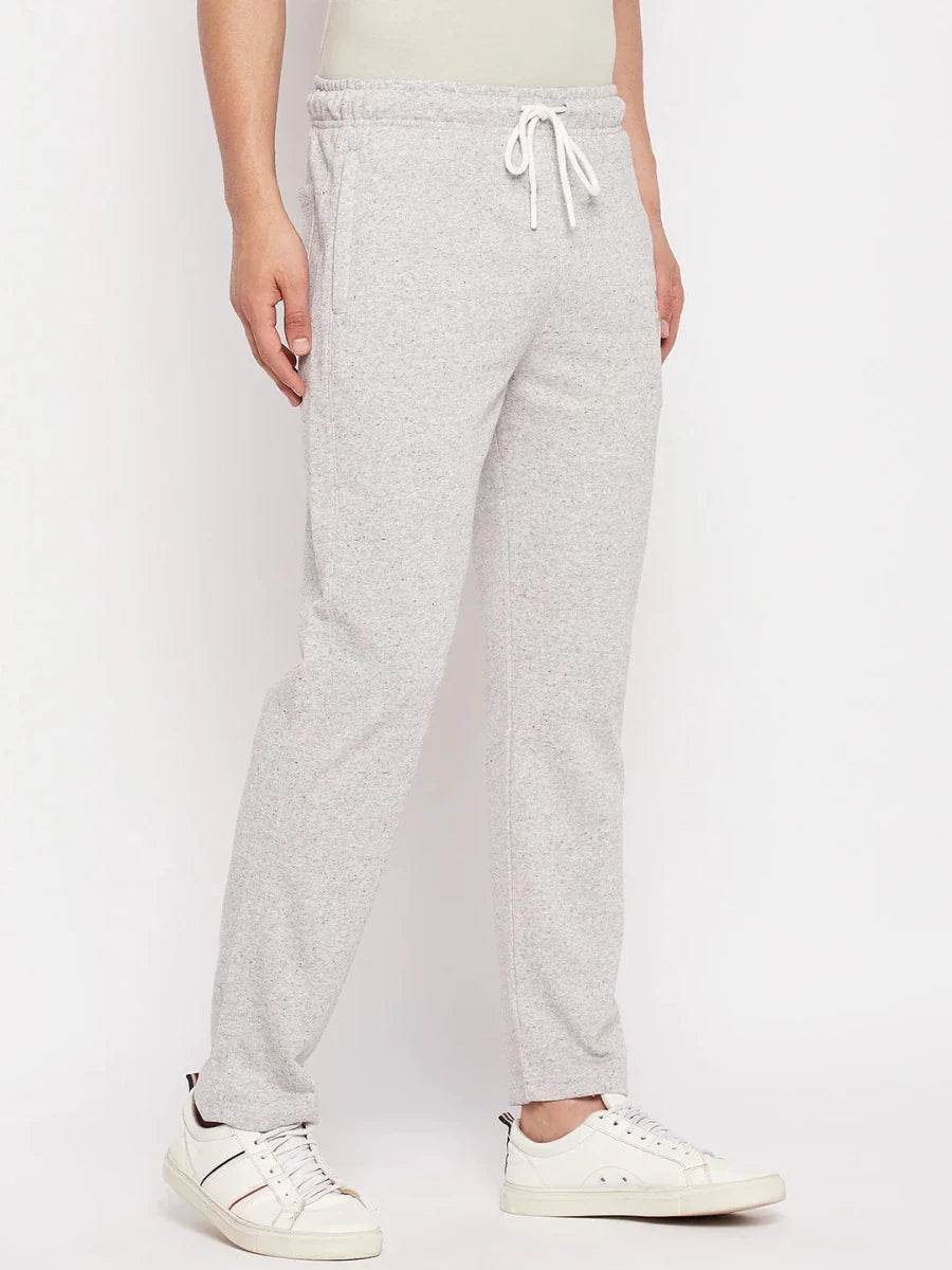 Model wears 98degreenorth Men's Light Grey French Terry Lycra Trackpants, perfect for summer athleisure and comfort.