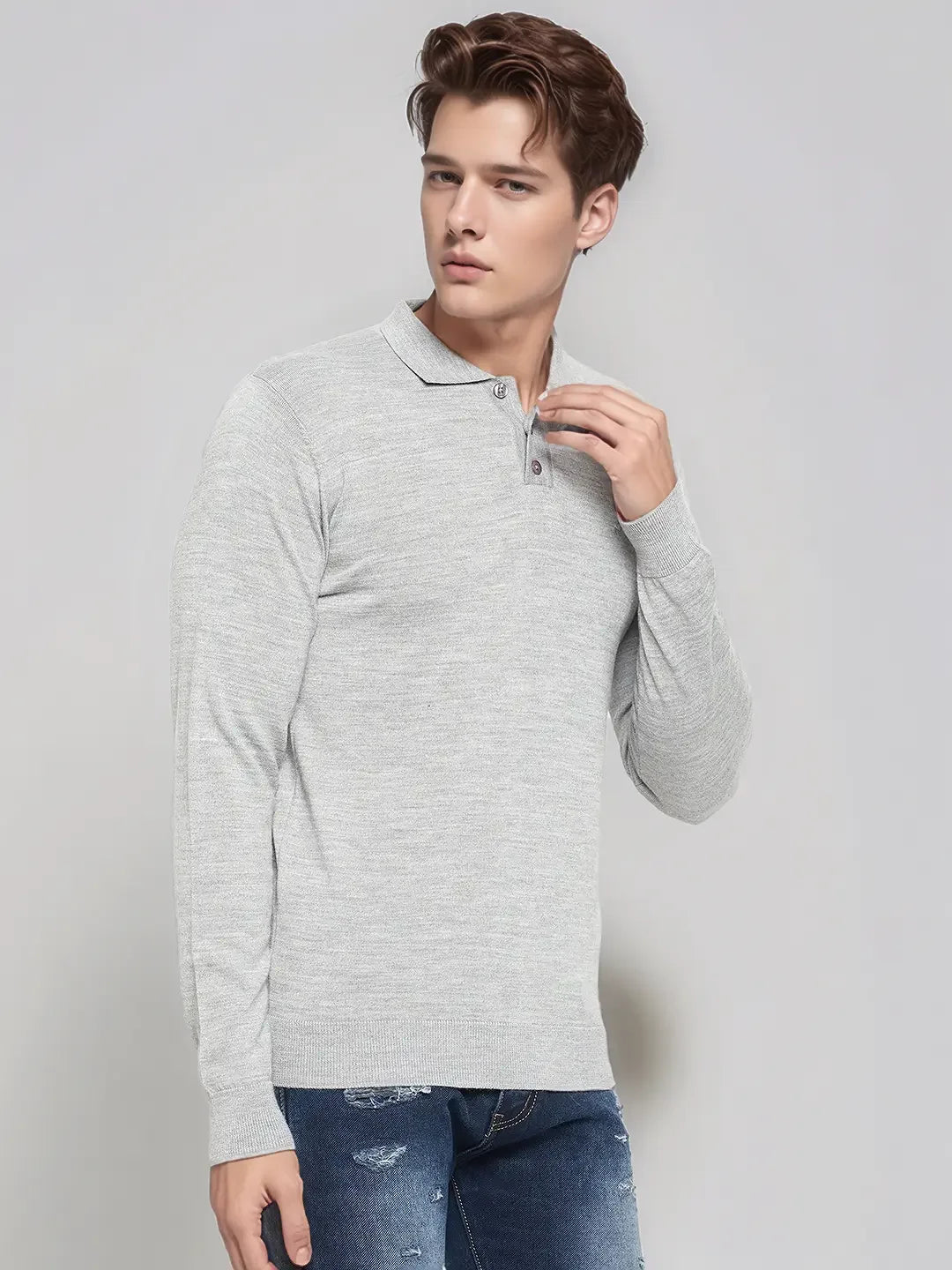 Man in 98degreenorth Men’s Light Grey Merino Wool Polo Sweater and blue ripped jeans, against a plain light background.