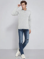 Man in 98degreenorth’s Light Grey Merino Wool Polo Sweater, blue jeans & white sneakers, against a plain background.