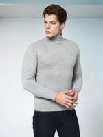 A man wears a 98degreenorth Men’s Light Grey Merino Wool Turtle Neck Sweater against a light background.