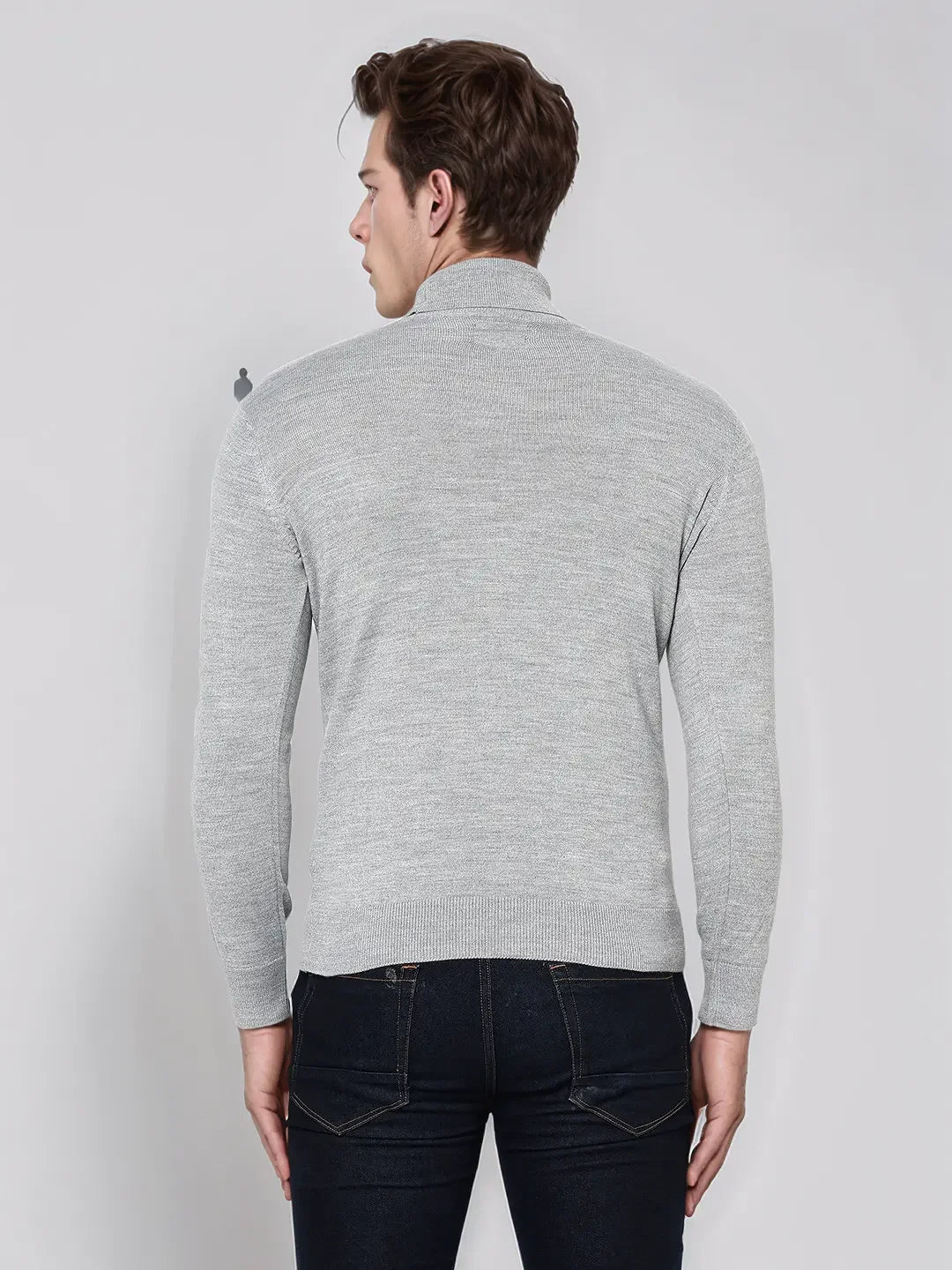 Man wears 98degreenorth Men’s Light Grey Merino Wool Turtle Neck Sweater with dark jeans, back to camera.