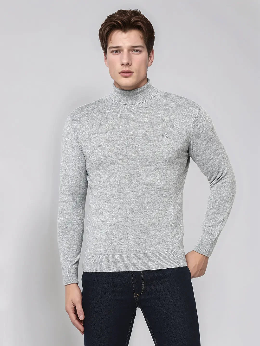 A man wears a 98degreenorth Men's Light Grey Merino Wool Turtle Neck Sweater against a light gray background.