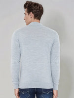 A man wears a 98degreenorth light grey merino wool turtle neck sweater with dark blue jeans, shown from the back.