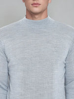 A man wears a 98degreenorth light grey merino wool turtleneck sweater, shown shoulder to mid-torso.