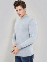 Man in 98degreenorth Light Grey Merino Wool Turtle Neck Sweater and blue jeans against a plain light background.