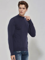 A man in a 98degreenorth Men’s Light Navy Merino Wool Turtle Neck Sweater and jeans poses against a light background.