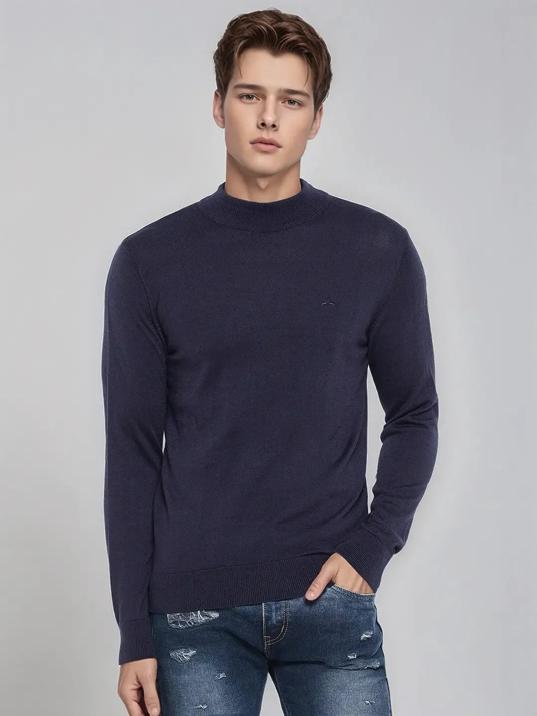 Young man in a 98degreenorth Men’s Light Navy Merino Wool Turtle Neck Sweater, standing with a hand in his pocket.
