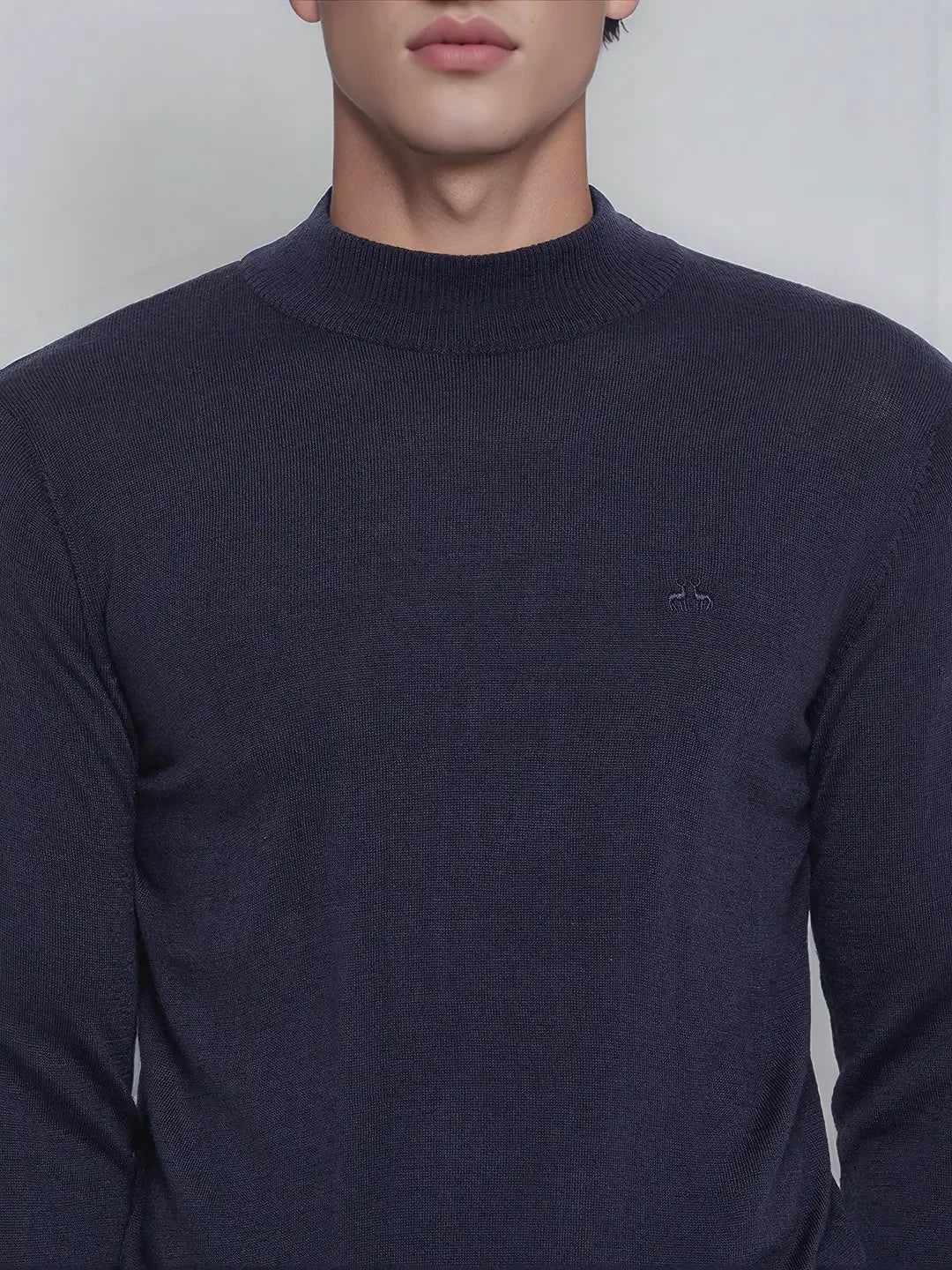 A man wears a 98degreenorth Light Navy Merino Wool Turtle Neck Sweater, shown from shoulders to upper chest.
