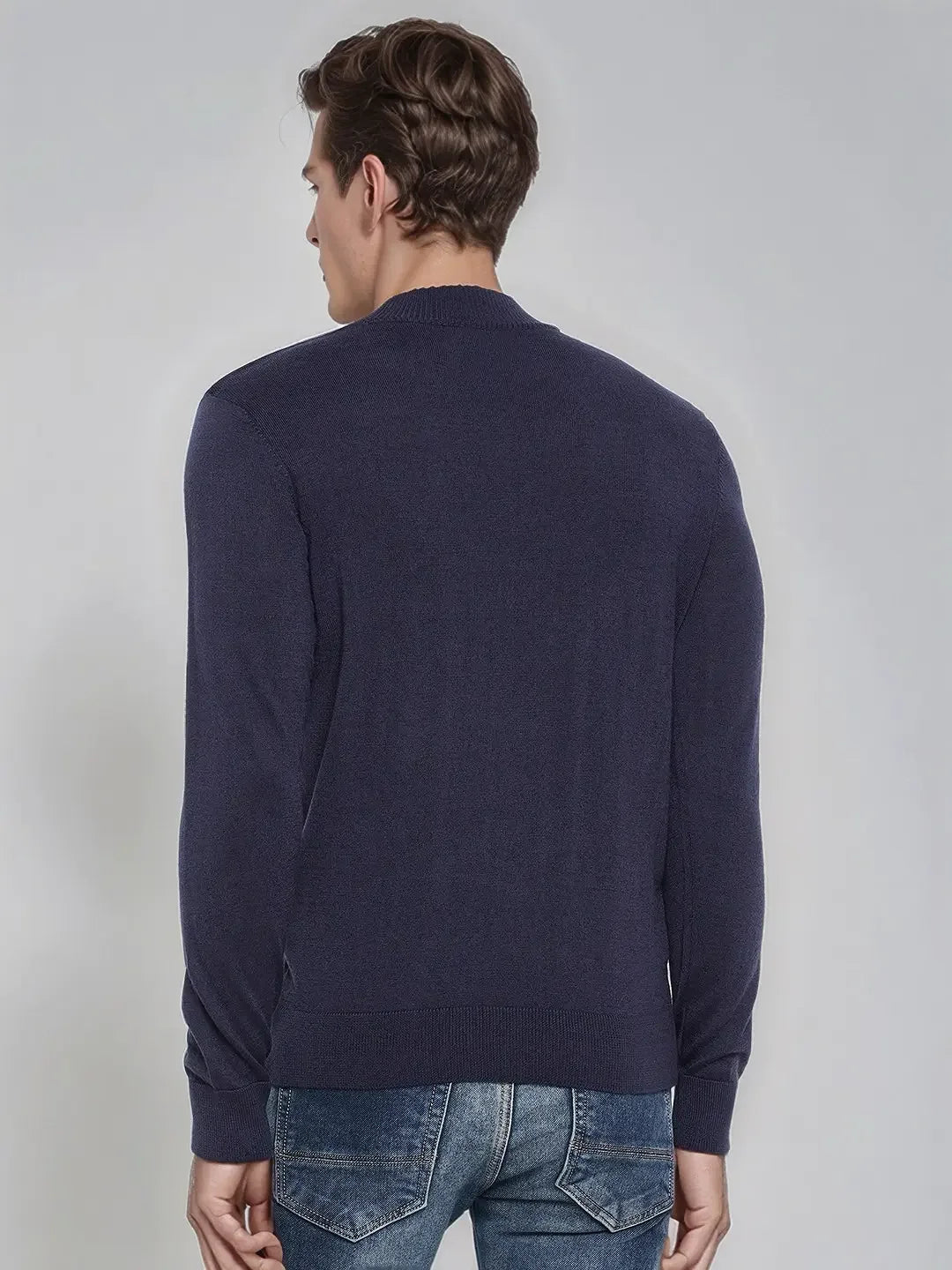 A man models the 98degreenorth Men’s Light Navy Merino Wool Turtle Neck Sweater, back view, against a plain backdrop.