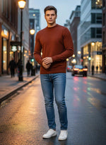 A man wears the 98degreenorth Men’s Maroon Merino Wool Turtle Neck Sweater on a wet city street at dusk.